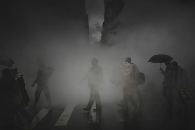 Zagađen vazduh u gradu, pešaci prolaze kroz gust smog na ulici