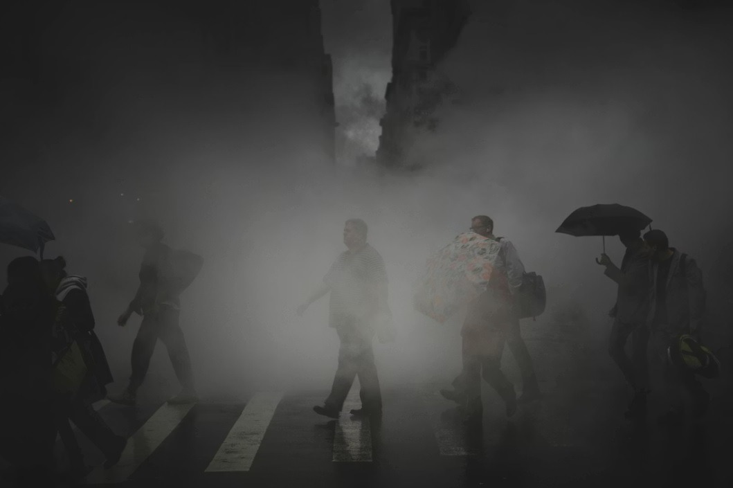 Zagađen vazduh u gradu, pešaci prolaze kroz gust smog na ulici