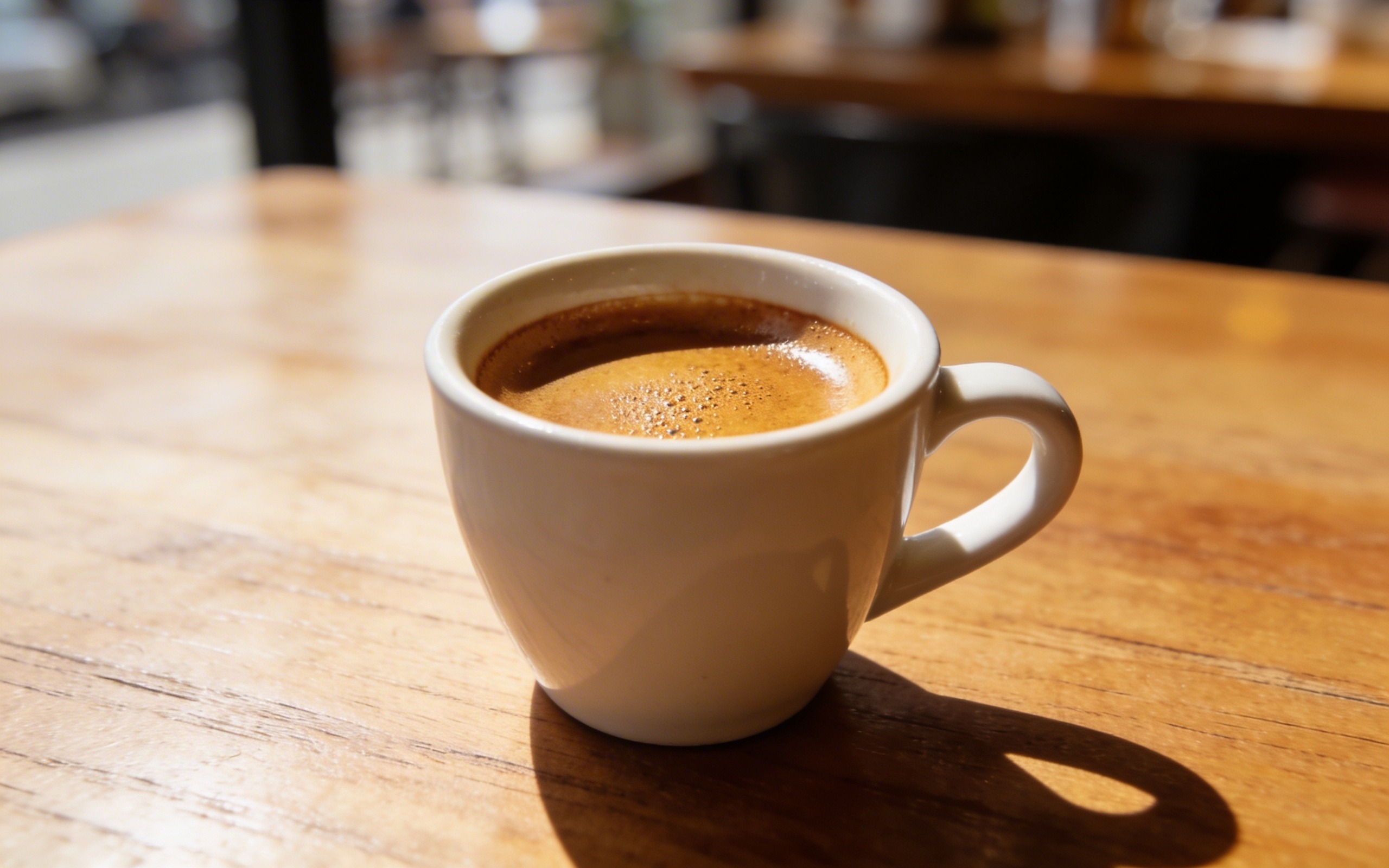 sveže pripremljen espresso u beloj šoljici na drvenom stolu, bogata krema, najbolja kafa za espresso aparat